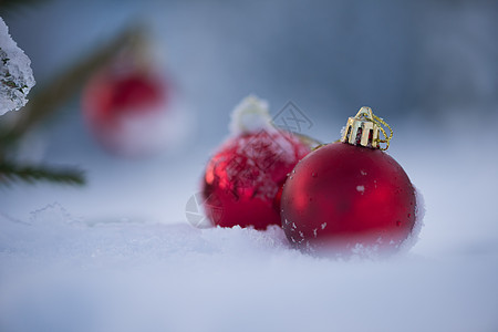 清雪中的红圣诞节球装饰假期派对庆典风格小玩意儿阴影装饰品雪花季节背景图片