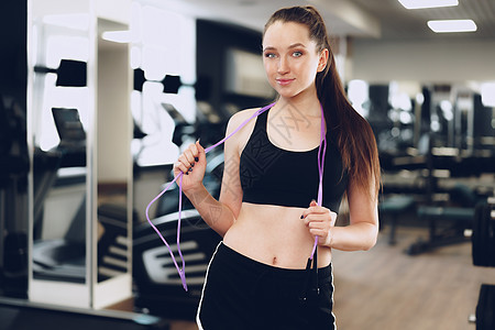 穿着跳绳的女孩的肖像 站在健身房里娱乐女士绳索运动装幸福女性工作室黑发活力训练图片