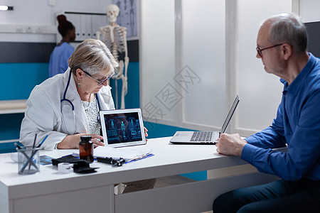医疗医生和病人分析数字平板电脑上人体的图解图片