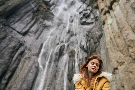 妇女黄色外套 旅游山山探险风景图片