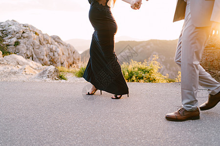 男人和孕妇在山上一条沥青路上行走 近一点图片