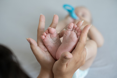 紧紧的婴儿小脚投标医生母亲父母手指按摩新生孩子按摩师生活图片