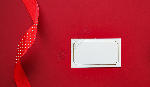假日品牌标识设计和圣诞平板概念 红色纸背景上的白色空白名片和圣诞装饰品作为平躺模型新年商业假期会员奢华笔记店铺包装问候语卡片图片