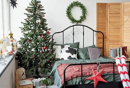 圣诞时装饰的美丽舒适的卧室假期装饰品礼物花环房子公寓沙发蜡烛展示房间图片