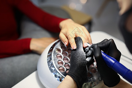 指甲总长使用特殊设备与客户修指甲工作工作室美容师沙龙女士程序修脚手指美甲创造力乐器图片