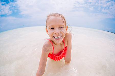 度假期间海滩上可爱的小女孩在caribbean度假帽子海洋海岸游客假期情感快乐异国热带海岸线图片