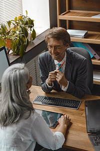两位主管一一对坐 谈笑风生 坐在现代办公室的电脑上工作的多民族商务人士 色调图像图片