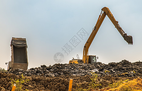 下午在建筑工地挖掘土木的挖土机 进行掘土和基础工程的后卫图片