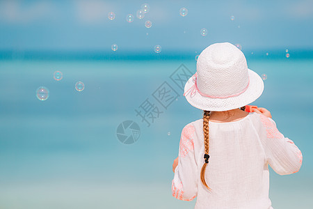 暑假时在沙滩上戴帽子的可爱小女孩支撑喜悦蓝色海滨热带微笑海岸线旅行地平线太阳镜图片