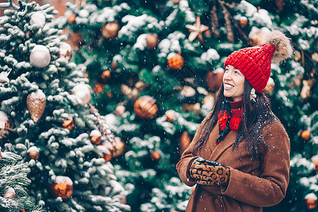 新的一年 在雪地的firtree树枝附近的快乐女孩童年市场微笑喜悦女士幸福孩子雪花新年地标图片