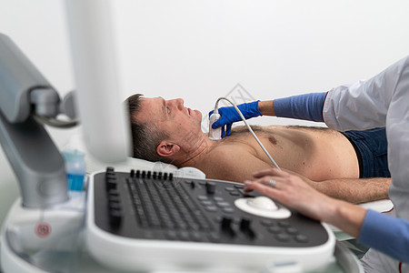 医生在心脏病诊所对一名男性患者进行多普勒超声检查 心脏病专家在心血管医院进行超声检查 超声心动图程序工具从业者超声波电脑男人治疗图片