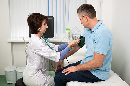 医疗和保健概念 男性中年高血压 高血压和中风前兆 体格检查 一般实践中的女医生测量诊所对患者的压力专家考试医院心脏病女性心脏病学图片