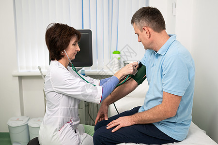 女医生在门诊办公室体检时用血压计给男病人测量血压 心脏病专家在心脏病医院检查男性患者的血压心血管女性低血压高血压乐器测试诊所有氧图片