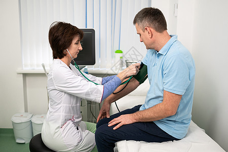 医疗和保健概念 男性中年高血压 高血压和中风前兆 体格检查 一般实践中的女医生测量诊所对患者的压力乐器心血管咨询职业低血压医疗保图片