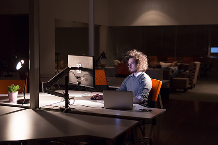 在暗办公室从事计算机工作的男子桌子商务员工商业互联网设计师人士桌面技术程序员图片