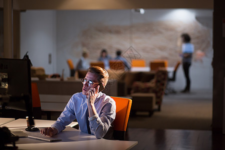 男子在暗办公室使用移动电话技术商业思维职业男性商务阅读程序员屏幕互联网图片