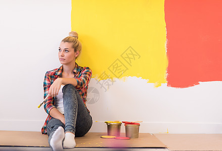 坐在地板上的年轻女画家女孩女郎装潢画笔设计师装修房间刷子快乐滚筒图片
