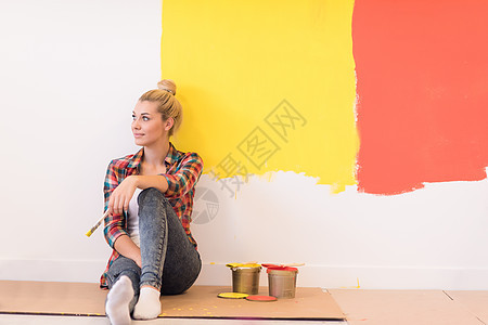 坐在地板上的年轻女画家快乐公寓设计师刷子房间金发微笑女士工作女性图片