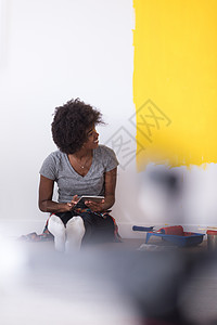 坐在地板上的后背女画家房子女孩刷子微笑房间滚筒公寓装潢快乐绘画图片