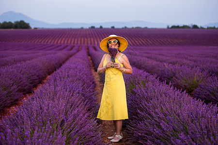 紫色渐变穿黄色洋装的亚洲女人 在熏衣草场戴帽子幸福旅行草地女性场地女孩女士紫色日落农村背景