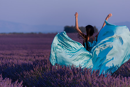 女性在熏衣草花田中天空自由喜悦紫色女士蓝色日落场地裙子幸福图片