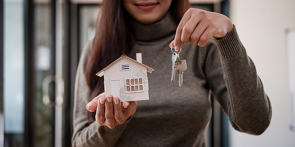 有房屋模型和钥匙的房地产经纪人妇女 抵押贷款报价和房屋保险概念图片