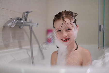小女孩在洗澡时用肥皂泡沫玩女孩卫生微笑浴缸女儿气泡乐趣婴儿家庭浴室图片