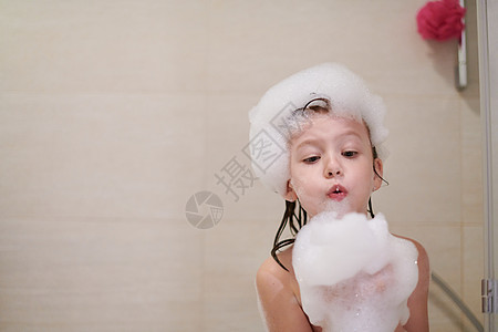小女孩在洗澡时用肥皂泡沫玩生活浴缸幼儿园浴室家庭头发女孩淋浴洗发水微笑图片