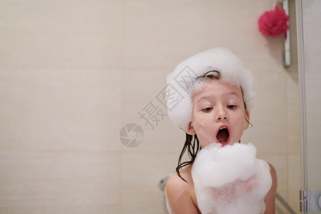 小女孩在洗澡时用肥皂泡沫玩浴室乐趣微笑牙齿女儿幼儿园生活浴缸头发喜悦图片