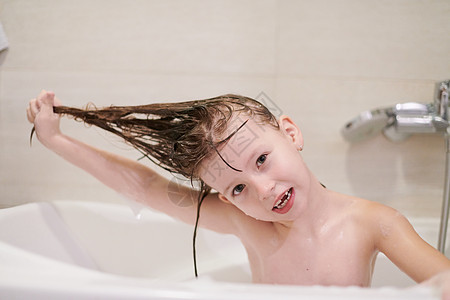 小女孩在洗澡时用肥皂泡沫玩头发洗发水婴儿喜悦家庭浴缸童年卫生淋浴微笑图片
