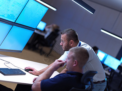 在安全数据系统控制室工作的男操作员 男性操作员信号男人键盘运营商展示监控房间工作站屏幕警卫图片