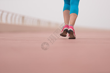 妇女忙着跑步在赛马场上运动员晴天活力时间女士运动装赛跑者锻炼天空慢跑者图片