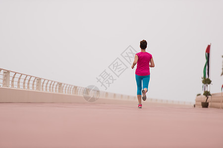 妇女忙着跑步在赛马场上成人晴天闲暇海洋女士锻炼运动装天空女性运动员图片