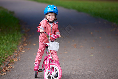 小女孩骑自行车骑自行车的小女孩活动孩子们童年喜悦家庭快乐闲暇孩子安全娱乐背景