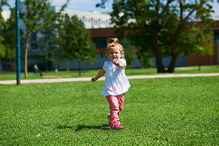 小女孩在公园玩得开心喜悦草地叶子头发乐趣女儿快乐童年婴儿场地图片