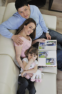 家庭幸福的家庭在家里看相片爸爸妈妈夫妻女孩女性照片母亲记忆团体女士图片