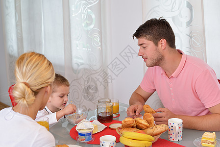 家庭在家中有健康早餐孩子们桌子食物孩子饮食母亲女士羊角妈妈微笑图片