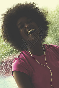 年轻美籍女子在体育场听音乐时的肖像娱乐身体舞蹈头发天气饮食微笑电话耳机女性图片