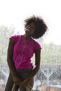 年轻美籍女子在体育场听音乐时的肖像女士电话运动员训练头发娱乐耳机身体天气舞蹈图片