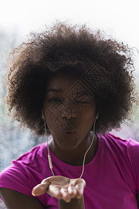 年轻美籍女子在体育场听音乐时的肖像运动员女孩身体耳机天气头发爆炸运动装音乐运动图片