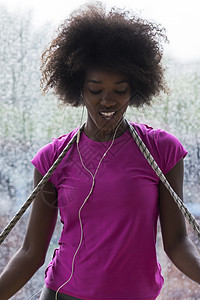 年轻美籍女子在体育场听音乐时的肖像头发训练身体天气女士娱乐运动员窗户音乐耳机图片