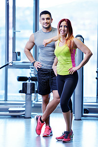健身房情侣在健身房的情侣拉丁男性训练身体损失锻炼运动服女士培训师重量背景