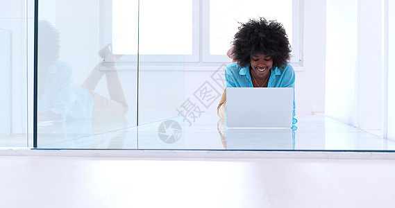 使用膝上型计算机在地板上工作的黑人妇女地面网络互联网女性女孩黑色微笑工作室头发电脑图片