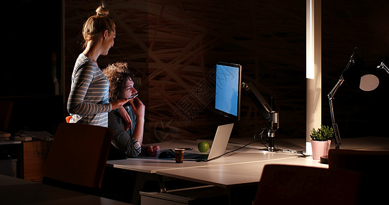 夜间办公室的年轻设计师男性互联网商务学习员工硬件监视器桌面工人桌子图片