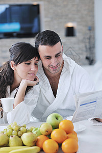 早餐时在厨房看报纸快乐的一对情侣黑发成人水果男人杯子乐趣女性女士男性家庭图片