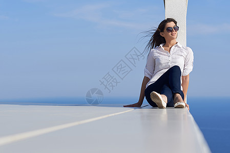 在现代豪华住宅前的放松妇女假期天空公寓咖啡女性奢华别墅旅行闲暇女孩图片