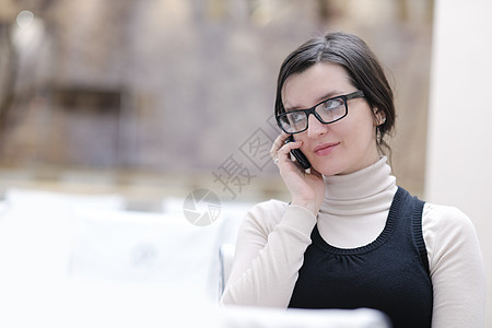 年轻妇女在电话上说话细胞女孩微笑房间成人女士管理人员快乐黑发眼镜图片