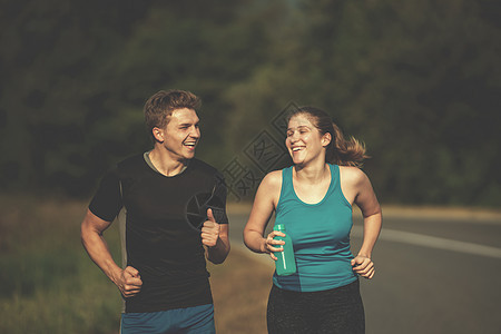 在乡村公路上慢跑的年轻夫妇运动装国家活力运动训练农村森林跑步女孩慢跑者图片