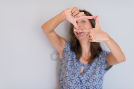 妇女展示手势的姿势成人摄影师女士相机微笑手指女孩照片棕榈快乐图片