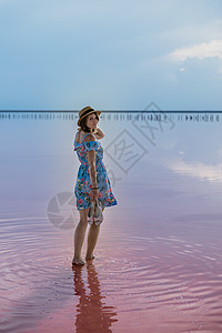 在著名的粉红盐湖上 女孩在日落时装扮幸福自由旅行女士风景裙子支撑游客女性帽子图片